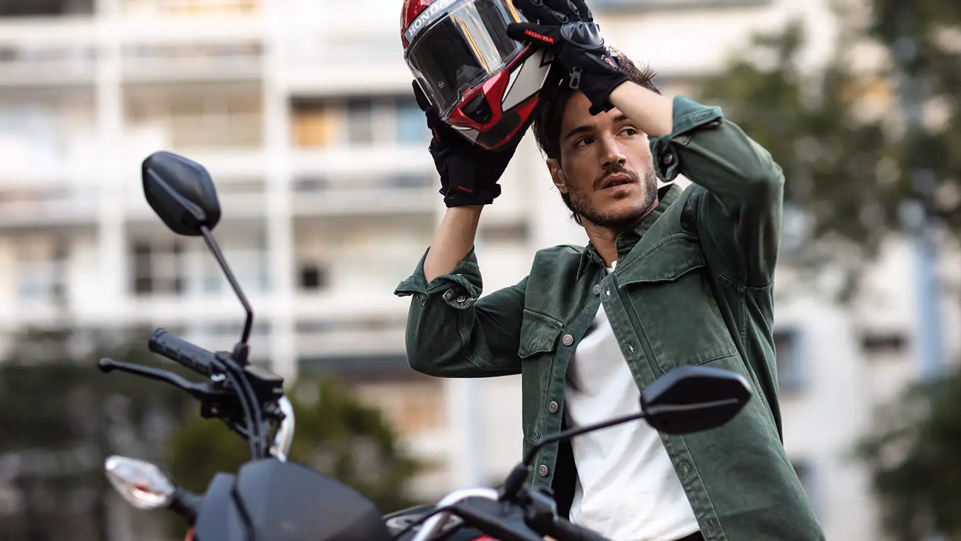 Homem colocando capacete ao lado da Honda CG 160 Fan - 6 de 9